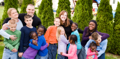 Eine Gruppe von Kinder, Teenager und Erwachsene stehen zusammen und lachen in die Kamera Eine Gruppe von Kinder, Teenager und Erwachsene stehen zusammen und lachen in die Kamera