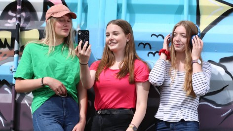 drei junge Mädchen stehen vor einer Graffiti Wand